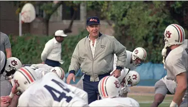  ?? BILL HABER — THE ASSOCIATED PRESS ?? Auburn football coach Pat Dye walks through his players as they begin workouts in preparatio­n for the Sugar Bowl in New Orleans on Dec. 27, 1988.