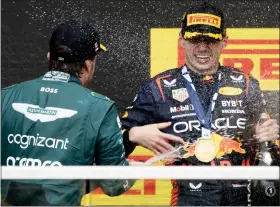  ?? PAUL CHIASSON — THE ASSOCIATED PRESS ?? Winner Max Verstappen is sprayed with champagne by second place finisher Fernando Alonso during victory ceremonies following the Canadian Grand Prix Sunday.
