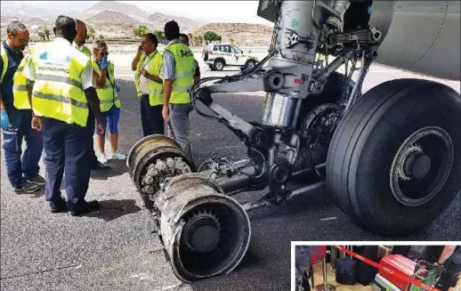  ??  ?? Damage: Officials examine the jet’s smashed wheels on the runway