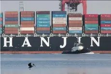  ?? DAVID MCNEW/AFP/GETTY IMAGES/FILES ?? A tugboat pulls away from the Hanjin Greece container ship at Long Beach, Calif., on Sept 10. An estimated $14 billion in goods are stranded on ships after the collapse of Hanjin.