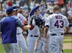  ?? SETH WENIG — THE ASSOCIATED PRESS ?? The Mets’ Jose Reyes, center, is mobbed by teammates after hitting a walk-off RBI single against the Cardinals at Citi Field on Thursday.