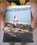  ?? AP photo ?? Reginalda Oliveira Costa shows a photo of her mother, Nally Oliveira da Costa, or “Aunt Uia,” in Rasa quilombo in Buzios, Brazil, in July. Oliveira, who died from symptoms of coronaviru­s, worked for years as a maid in the beach resort of Armacao dos Buzios.