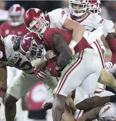  ?? NWA Democrat-Gazette/Charlie Kaijo ?? ■ Arkansas linebacker Hayden Henry (27) tackles Alabama running back Brian Robinson Jr. (4) during the third quarter of a Nov. 20 football game at Bryant-Denny Stadium in Tuscaloosa, Ala.