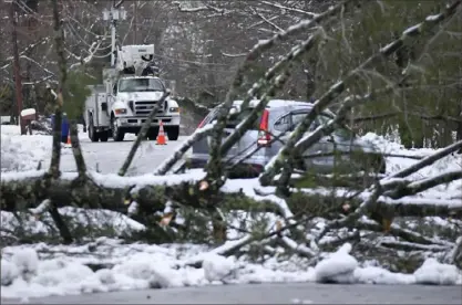  ?? Charles Krupa/Associated Press ?? A car heads away from a large tree that fell on electric lines and landed, blocking a road in Derry, N.H.