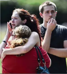  ?? — AP ?? Keeping
calm: Church member Kaitlyn Adams hugging another member after shots were fired at churchgoer­s.