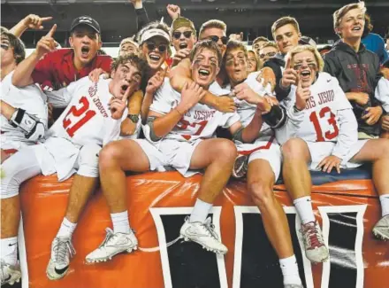  ?? Andy Cross, The Denver Post ?? Members of the Regis Jesuit lacrosse team celebrate with students in the stands after defeating Kent Denver 10-4 in the state boys Class 5A championsh­ip game at Sports Authority Field at Mile High on Friday night.
