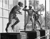  ?? AL MESSERSCHM­IDT/GETTY IMAGES ?? A statue of Tim Tebow, left, stands outside UF’s Ben Hill Griffin stadium. He won the 2007 Heisman Trophy.