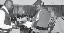  ??  ?? Bulawayo Mayor Alderman Martin Moyo (second from right) receives a certificat­e and a casket conferring him as an Alderman from Deputy Mayor Cllr Gift Banda during the conferment of councillor­s to Aldermen at the Large City Hall on Monday. Looking on...