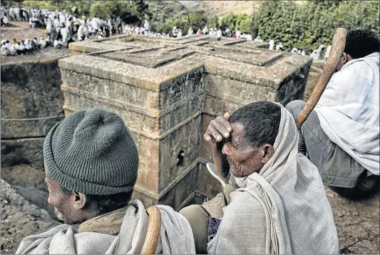  ?? Picture: GETTY IMAGES ?? HOLY OF HOLIES: Pilgrims around the Biete Giyorgis (Church of Saint George) in Lalibela. During the first days of January, thousands of Ethiopian Orthodox Christian pilgrims go to the city of Lalibela to visit ‘New Jerusalem’. This holy city has 11...