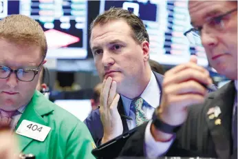  ?? (AP FOTO) ?? PAUSE FOR EFFECTS. In this June 29, 2016 file photo, trader Jonathan Corpina (center) works on the floor of the New York Stock Exchange. One week after Britain’s vote to quit the EU sent markets into a tailspin, investors seem to be taking a more...