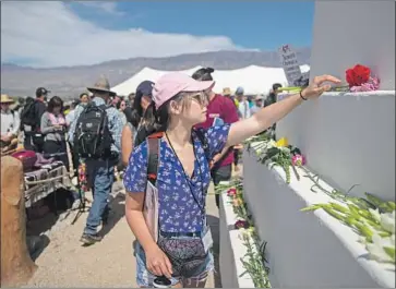  ?? Kent Nishimura Los Angeles Times ?? ALANA MOUCHARD of Irvine places a f lower on a monument at the Manzanar camp in April.