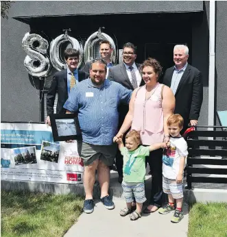  ??  ?? Celebratin­g a milestone in attainable home ownership are, front row, Bill Douros, Vicky Koutroumpi, and their children Pano and Nikolas; back row, John Harrop, president and CEO of Attainable Homes Calgary, Greg Gutek, president and founder, Partners...