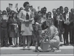  ?? The Associated Press ?? NEW VIEW: First lady Melania Trump is greeted by Malawi first lady Gertrude Maseko and a flower girl as she arrives at Lilongwe Internatio­nal Airport, in Lumbadzi, Malawion Thursday. Mrs. Trump is visiting Africa on her first big solo internatio­nal trip, aiming to make child well-being the focus of a five-day, four-country tour.