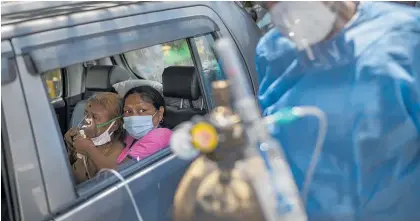  ?? Photo / AP ?? A Covid-19 patient receives oxygen as she waits for a hospital bed.