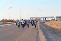  ?? ?? Walkers passing through the Orapa South Gate on their way back to Itekeng stadium