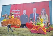  ?? Rajesh Kumar Singh, The Associated Press ?? Indian folk dancers rehearse their performanc­e next to a billboard featuring Indian Prime Minister Narendra Modi, U.S. President Donald Trump and first lady Melania Trump at the airport in Agra, India, on Sunday.