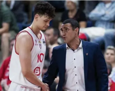  ?? FOTO BELGA ?? Coach Roel Moors feliciteer­t Hans Vanwijn. “We waren de jongste ploeg van het kampioensc­hap.”