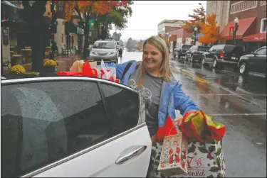  ?? Photos by Terrance Armstard ?? Christmas shopping: Nichol Greer places Christmas gifts in her car after shopping on Black Friday at Martha’s on the Square. Below, Bertie Coleman of Hampton does Christmas shopping at The Personal Touch store.