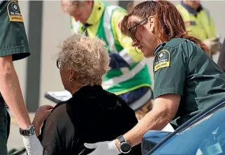  ?? PHOTOS: MATT SHAND/STUFF ?? Emergency services staff attend to a woman after she was rescued from a hole yesterday.