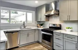  ??  ?? Updated kitchen with beautiful quartz slab counters, tile backsplash, plenty of cabinetry with soft-close drawers and recessed lights. Stainless appliances include a new Frigidaire 4-burner gas range plus griddle, new vent hood and Whirlpool dishwasher.