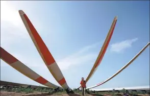  ?? LUO XUEFENG / XINHUA ?? A technician checks wind turbine blades at a plant in Weixian county, Hebei province.
