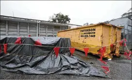  ?? CURTIS COMPTON / CCOMPTON@AJC.COM ?? A constructi­on dumpster and covered materials sit outside Dresden Elementary School on Monday in Chamblee. Of the school’s 29 active maintenanc­e requests, nine are for leaks in classrooms and hallways, or for standing water.