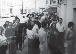  ?? Juan Clark Collection ?? Cuban refugees who arrived in the U.S. on Freedom Flights stand in line outside the Freedom Tower in downtown Miami, where they received food and medical care.