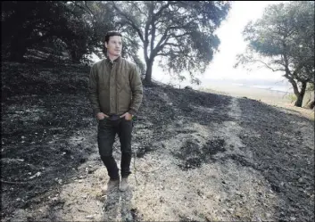  ?? Rich Pedroncell­i The Associated Press ?? Adam Mariani in a burned area Wednesday of the Scribe Winery in Sonoma, Calif. The winery was almost destroyed by the fire, but Mariani, with family members and employees, worked through the night to keep it from burning.