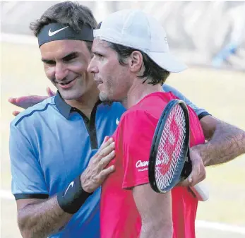  ?? FOTO: DPA ?? Zusammen sind sie 74 Jahre jung: Tommy Haas (rechts) schlägt den Rasen-Experten Roger Federer und wird von seinem Schweizer Kumpel beglückwün­scht.
