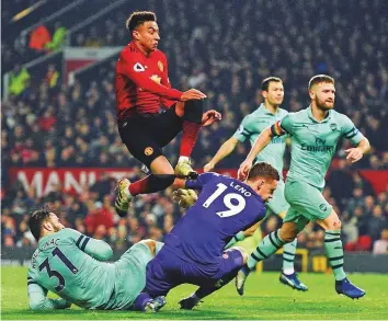  ?? AFP ?? Manchester United’s Jesse Lingard (top) jumps past Arsenal goalkeeper Bernd Leno (centre) after scoring their second goal to equalise 2-2 at Old Trafford on Wednesday.