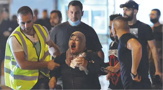  ??  ?? Palestinia­ns assist a wounded woman amid clashes with Israeli security forces in Jerusalem's Old City. Picture: AFP