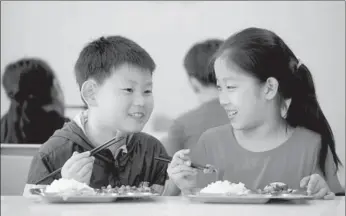  ?? ZHANG WENKUI / XINHUA ?? Students dine in May at Shenyang Railway No 3 Primary School, a model school for student nutrition in Liaoning province.