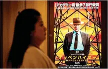 ?? — AFP photo ?? File photo shows a woman walking past an advertisem­ent of ‘Oppenheime­r’ in Tokyo.