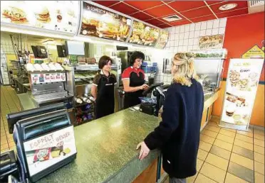  ??  ?? Die armenische Wirtschaft­sstudentin Gayane Odabashyan (links) und Sibylle Rapka bedienen eine Kundin im Mcdonald’srestauran­t auf dem Weimarer Berg. Foto: Klaus Jäger