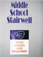  ??  ?? A sign on the stairwell states that face masks are required at OCPS Academic Center for Excellence in Orlando.