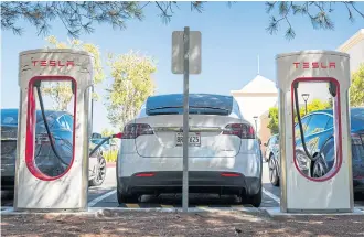  ?? BLOOMBERG ?? A Tesla vehicle charges at a charging station in San Mateo, California on Tuesday.