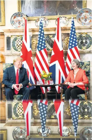  ??  ?? Conviviali­ty in the Great Hall at Chequers, above, and, in the country retreat’s garden, the president gently takes Mrs May’s arm following a press conference