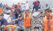  ?? CHINATOPIX/AP ?? Emergency personnel and local people work at the site of a landslide in Xinmo village in southweste­rn China’s Sichuan Province on Saturday.