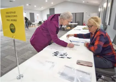  ?? STAFF PHOTOS BY MATT HAMILTON ?? Deborah Lubell, right, checks a voter’s driver’s license Tuesday at Meadowview Baptist Church in Georgetown. Participat­ion in Tuesday’s presidenti­al primary was down 37 percent from 2020 in Hamilton County.
