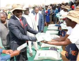  ??  ?? Vice President Kembo Mohadi hands over maize seed and fertiliser­s to beneficiar­ies at the launch of the 2018 Presidenti­al Inputs Support Scheme in Lutumba, Beitbridge, in September