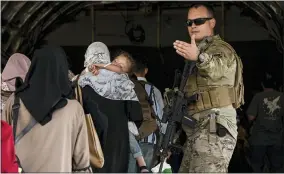  ?? SENIOR AIRMAN TAYLOR CRUL/U.S. AIR FORCE VIA AP ?? In this image provided by the U.S. Air Force, a U.S. Air Force Airman guides evacuees aboard a U.S. Air Force C-17globemas­ter III at Hamid Karzai Internatio­nal Airport in Kabul, Afghanista­n, Tuesday, Aug. 24, 2021.