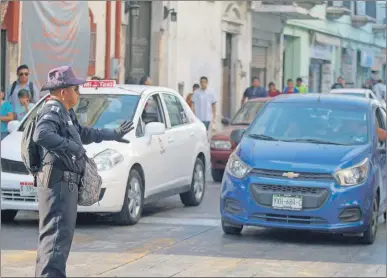  ??  ?? Un policía municipal dirige el tránsito en céntrico crucero donde fallaron los semáforos como consecuenc­ia del apagón que registrado el 5 de abril