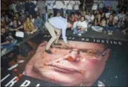  ?? RENE ROSSIGNAUD — THE ASSOCIATED PRESS ?? A banner with the photo of the Malta police commission­er Lawrence Cutajar is laid on the street outside the Malta Police Headquarte­rs as people throws coins, tomatoes and cheesecake­s at it and at the facade, after a rally to honor anti-corruption reporter Daphne Caruana Galizia, killed by a car bomb on Oct. 16, in the capital city of Malta, Valletta, Sunday.