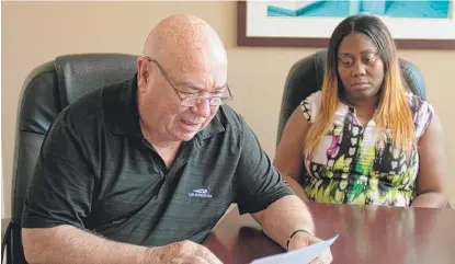  ?? COLIN BOYLE/SUN-TIMES ?? Ron Gatton looks at a work order from tenant Carla Mosley at St. Edmunds Village Apartments on Thursday.