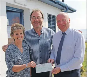  ??  ?? Howdens representa­tive Vince Gilligan presents a cheque to committee members Lesley Wood and Ian Cook.