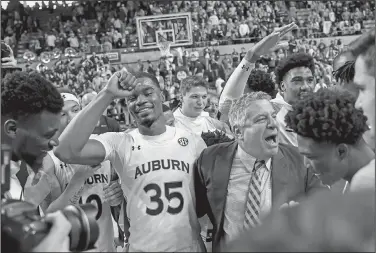  ?? Associated Press ?? Celebratin­g: Auburn head coach Bruce Pearl celebrates with players after a win over Tennessee in an NCAA college basketball game Saturday in Auburn, Ala.