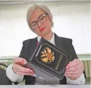  ?? AP PHOTO ?? An election commission official inspects the passport of a person who came to vote at a polling station Friday during a presidenti­al election in Makiivka, Russian-controlled Donetsk region of eastern Ukraine.