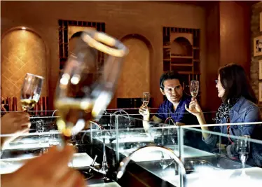  ??  ?? Tourists taste ice wine in the Gansu Qilian Winery Co., Ltd wine cellar.