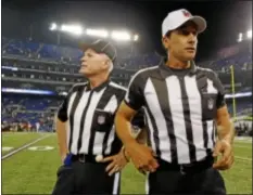  ??  ?? Referee Gene Steratore, right, and back judge Bob Waggoner look around the field before Thursday’s game in Baltimore. The NFL’s real referees were back to work for the first time as the lockout ended.