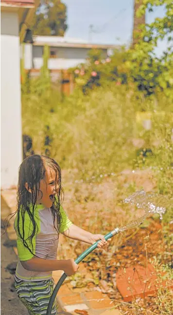  ?? ELIZABETH WEINBERG/THE NEW YORK TIMES ?? There are many ways for children to stay wet and cool even when a trip to the local pool is not possible.